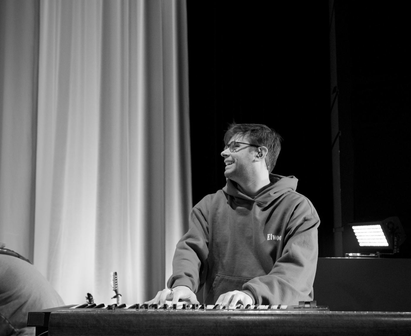 Black and white portrait, smiling at the keys backstage